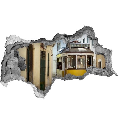 Adesivo con vista dietro il muro Un tram giallo in una strada stretta