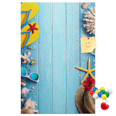 Bacheca di sughero con accessori estivi su sfondo di legno blu