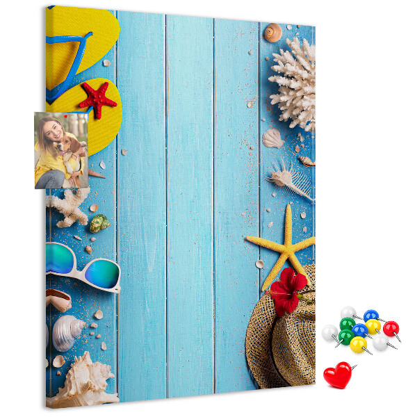 Bacheca di sughero con accessori estivi su sfondo di legno blu