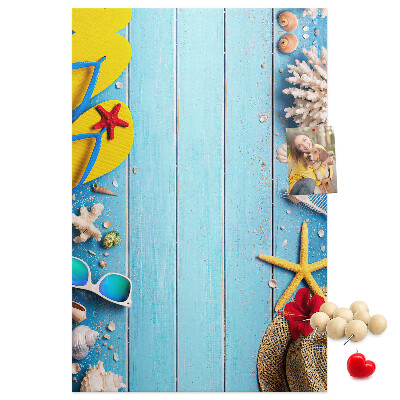 Bacheca di sughero con accessori estivi su sfondo di legno blu