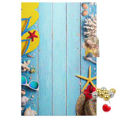 Bacheca di sughero con accessori estivi su sfondo di legno blu