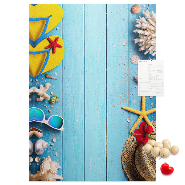 Bacheca di sughero con accessori estivi su sfondo di legno blu