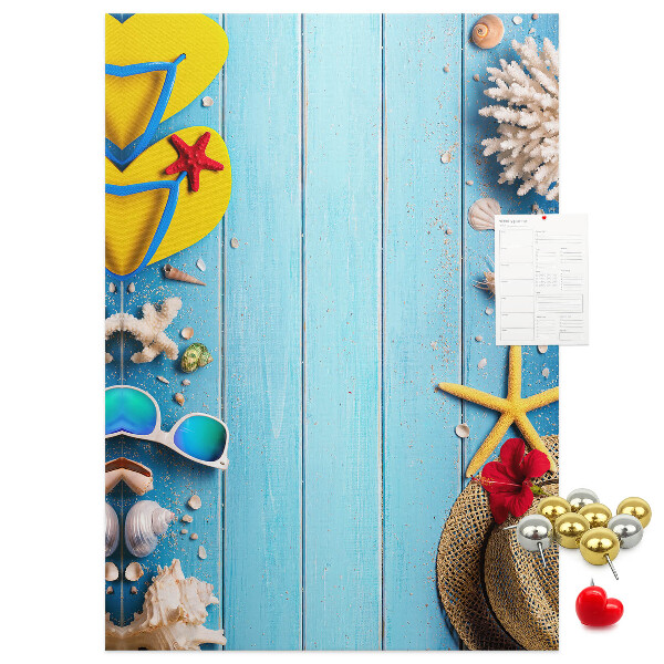 Bacheca di sughero con accessori estivi su sfondo di legno blu