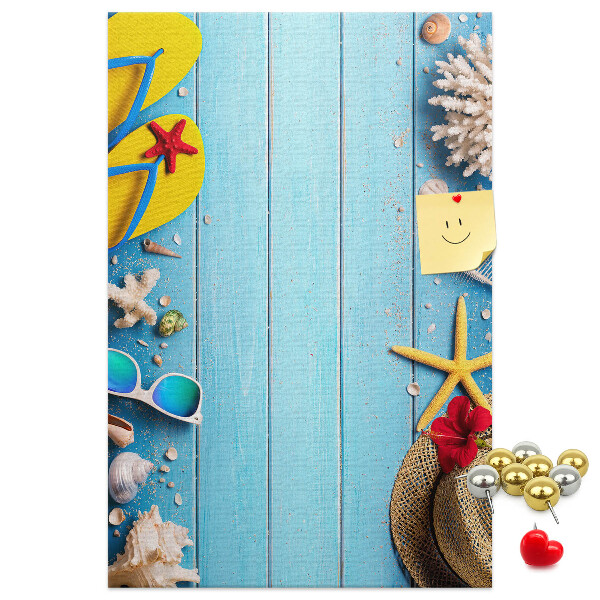 Bacheca di sughero con accessori estivi su sfondo di legno blu