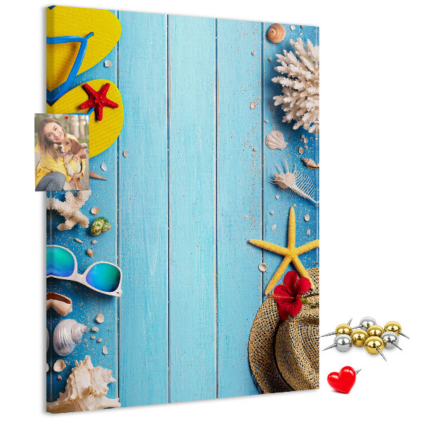 Bacheca di sughero con accessori estivi su sfondo di legno blu