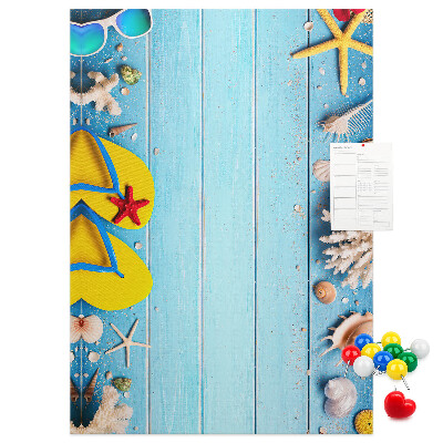 Lavagna in sughero con accessori estivi da spiaggia su sfondo blu
