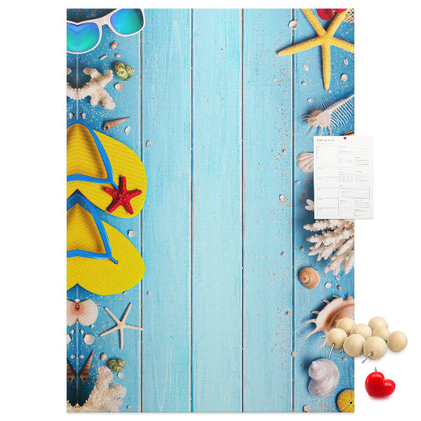 Lavagna in sughero con accessori estivi da spiaggia su sfondo blu
