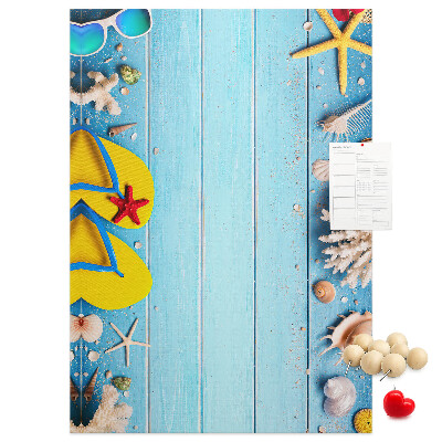 Lavagna in sughero con accessori estivi da spiaggia su sfondo blu
