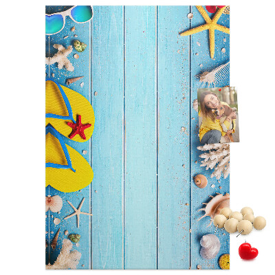 Lavagna in sughero con accessori estivi da spiaggia su sfondo blu