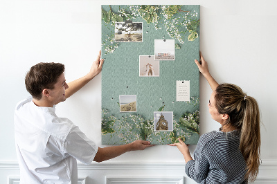 Bacheca di sughero con stampa di fiori e foglie delicate su sfondo verde