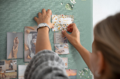 Bacheca di sughero con stampa di fiori e foglie delicate su sfondo verde