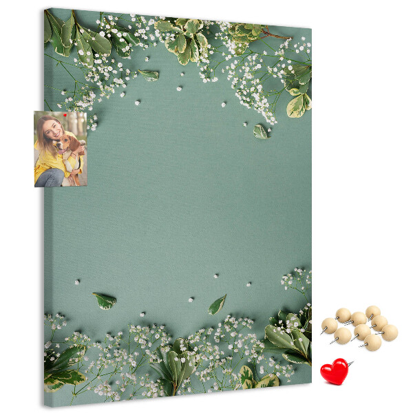 Bacheca di sughero con stampa di fiori e foglie delicate su sfondo verde