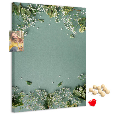 Bacheca di sughero con stampa di fiori e foglie delicate su sfondo verde