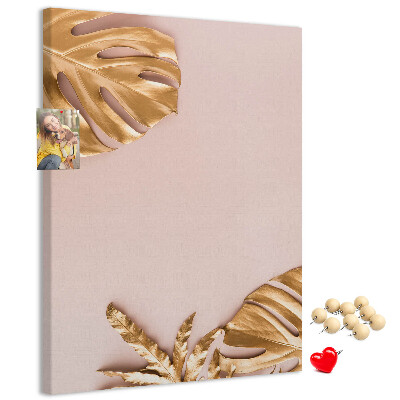 Bacheca di sughero con foglie dorate su delicato sfondo rosa