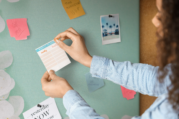 Bacheca di sughero con dettagli floreali su sfondo pastello