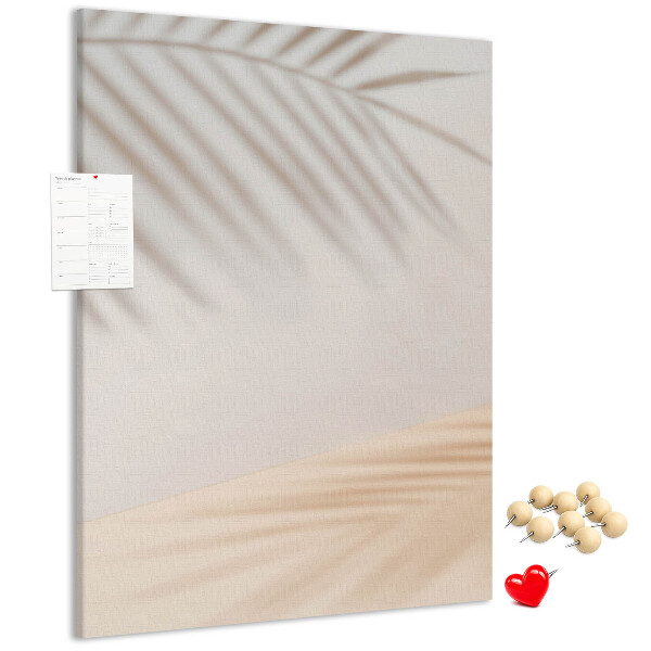 Bacheca di sughero con delicate ombre di palme su sfondo chiaro