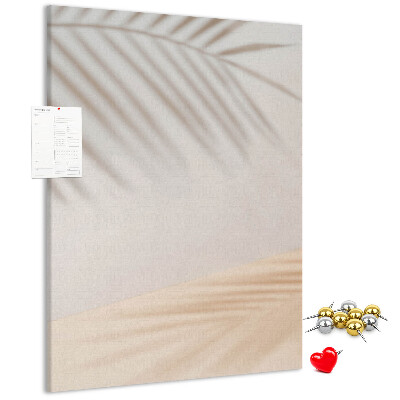 Bacheca di sughero con delicate ombre di palme su sfondo chiaro