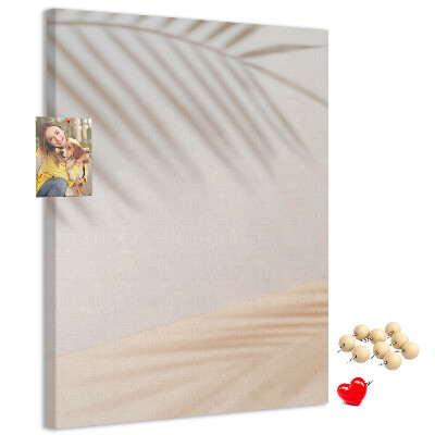 Bacheca di sughero con delicate ombre di palme su sfondo chiaro