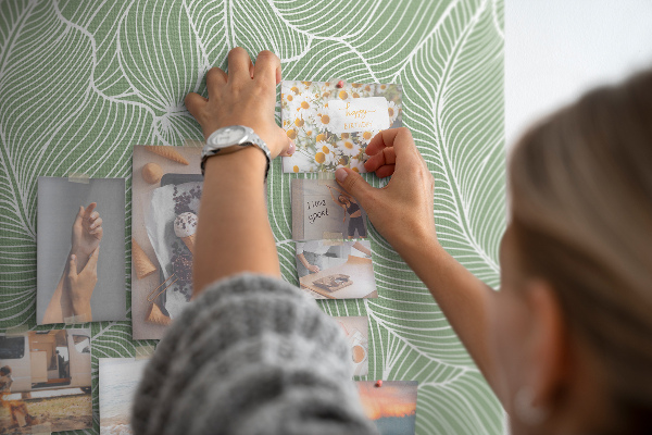 Bacheca di sughero con stampa di foglie delicate su sfondo verde