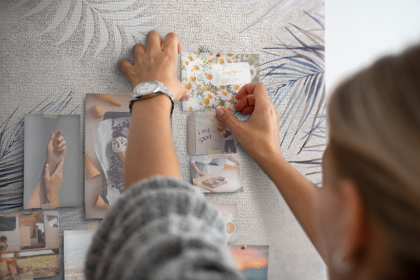 Bacheca di sughero con stampa di foglie delicate su sfondo grigio
