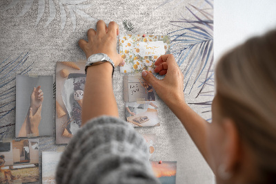 Bacheca di sughero con stampa di foglie delicate su sfondo grigio