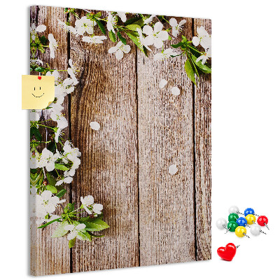 Lavagna in sughero con stampa di fiori su sfondo di assi di legno