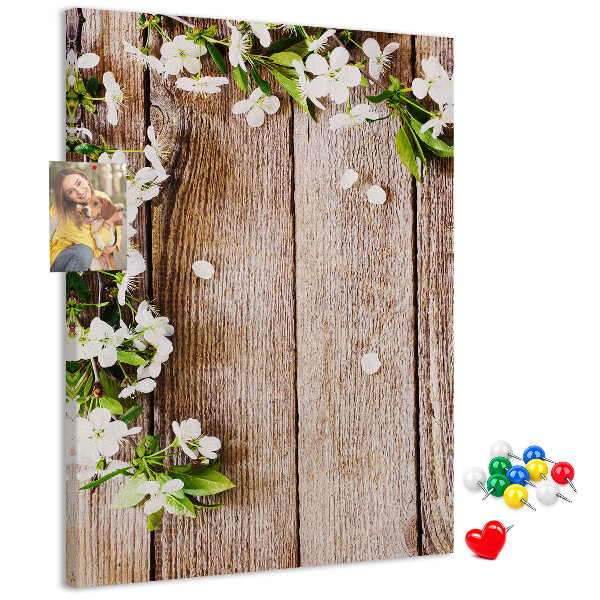 Lavagna in sughero con stampa di fiori su sfondo di assi di legno