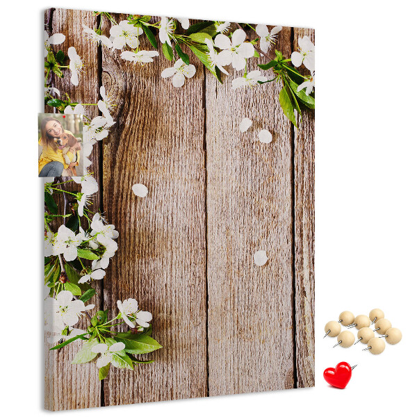 Lavagna in sughero con stampa di fiori su sfondo di assi di legno