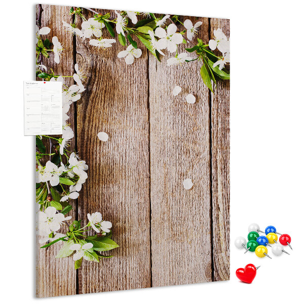 Lavagna in sughero con stampa di fiori su sfondo di assi di legno