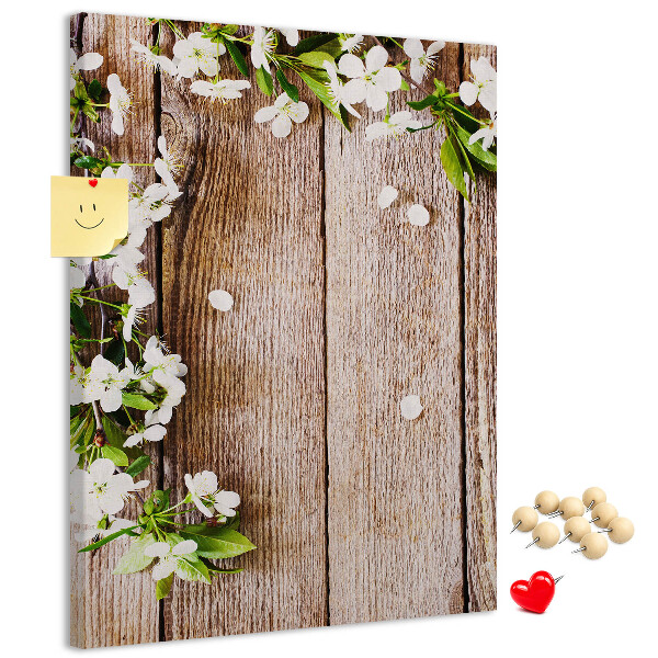 Lavagna in sughero con stampa di fiori su sfondo di assi di legno