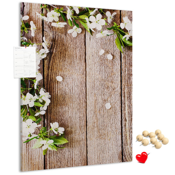 Lavagna in sughero con stampa di fiori su sfondo di assi di legno