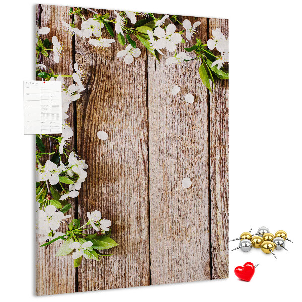 Lavagna in sughero con stampa di fiori su sfondo di assi di legno