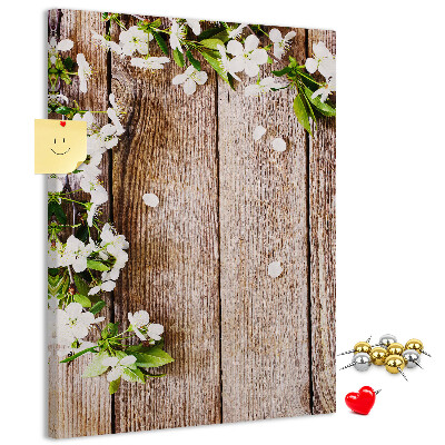 Lavagna in sughero con stampa di fiori su sfondo di assi di legno