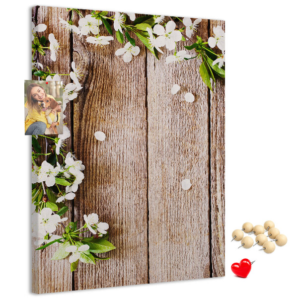Lavagna in sughero con stampa di fiori su sfondo di assi di legno