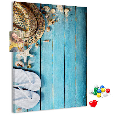 Lavagna in sughero con accessori estivi su sfondo in legno blu