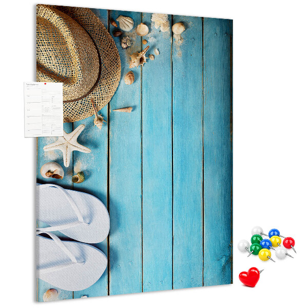Lavagna in sughero con accessori estivi su sfondo in legno blu