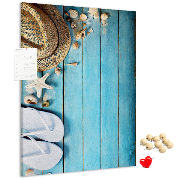 Lavagna in sughero con accessori estivi su sfondo in legno blu