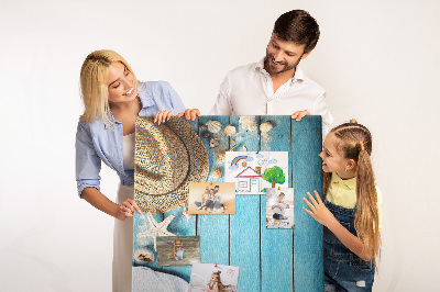 Lavagna in sughero con accessori estivi su sfondo in legno blu