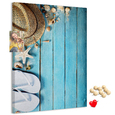 Lavagna in sughero con accessori estivi su sfondo in legno blu