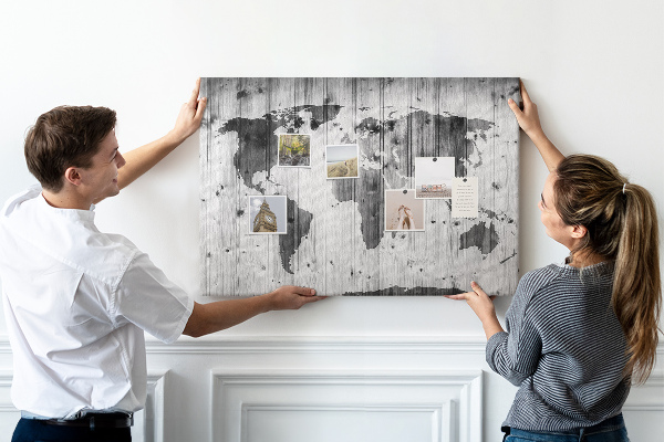 Lavagna di sughero con mappa del mondo su sfondo di assi di legno