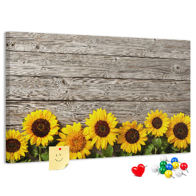 Lavagna di sughero con stampa di girasoli su sfondo di assi di legno