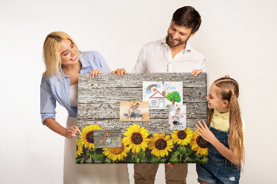 Lavagna di sughero con stampa di girasoli su sfondo di assi di legno