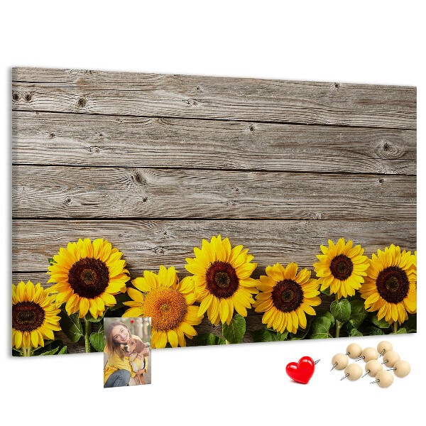 Lavagna di sughero con stampa di girasoli su sfondo di assi di legno