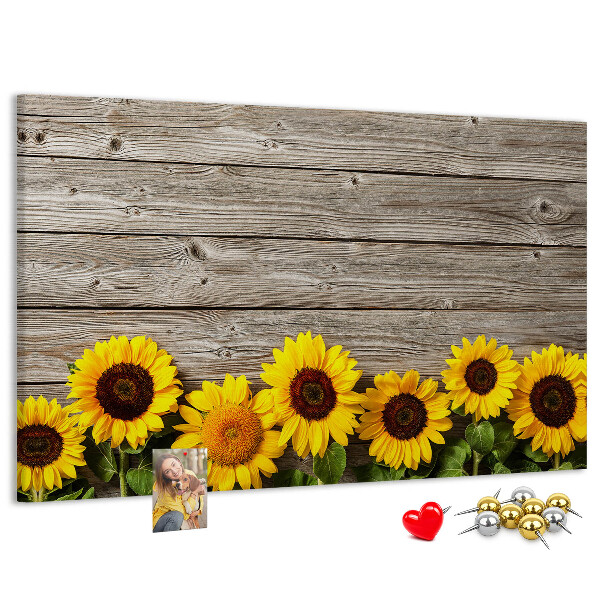 Lavagna di sughero con stampa di girasoli su sfondo di assi di legno