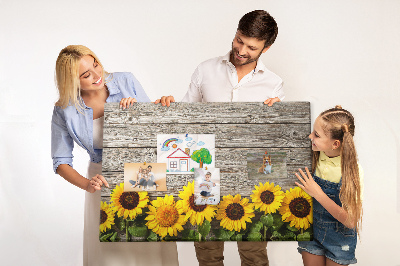 Lavagna di sughero con stampa di girasoli su sfondo di assi di legno