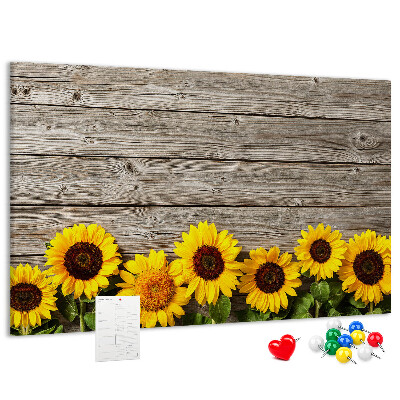 Lavagna di sughero con stampa di girasoli su sfondo di assi di legno