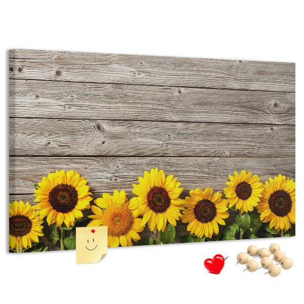 Lavagna di sughero con stampa di girasoli su sfondo di assi di legno