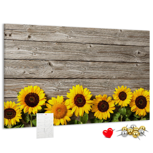 Lavagna di sughero con stampa di girasoli su sfondo di assi di legno