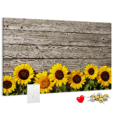 Lavagna di sughero con stampa di girasoli su sfondo di assi di legno