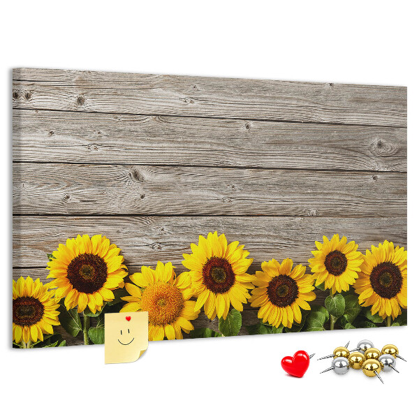 Lavagna di sughero con stampa di girasoli su sfondo di assi di legno